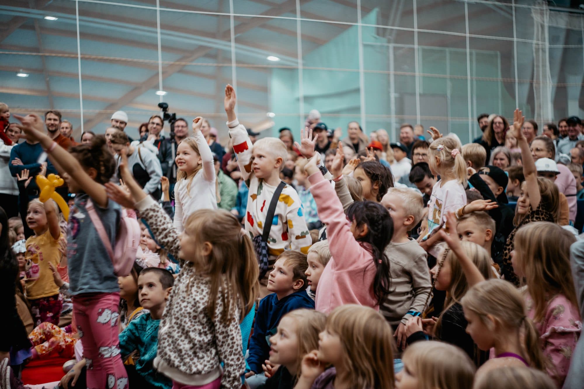 Koko yleisö nostaa kädet ylös kohti lavaa